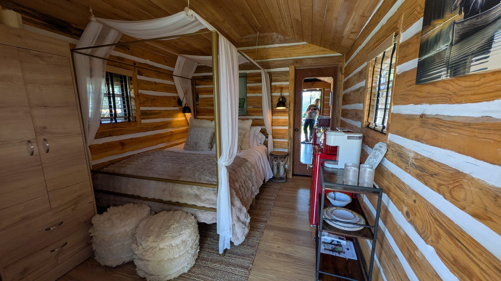 Warmly lit canopy bed inside Izzy's Log Cabin at Watson's Lakefront Resort