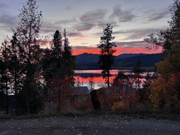 A red boat on Rose Lake at sunset in autumn — the launch point for swimming, kayaking, and fishing at Watson's