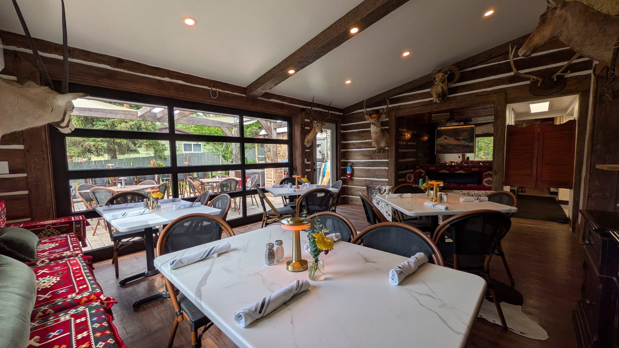 Warm dining room at Red's Tavern with marble banquette and mountain-view window at Watson's Lakefront Resort