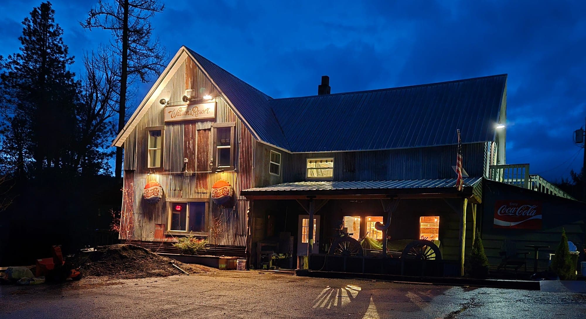 Watson's Lakefront Resort at blue hour with warm interior lights spilling onto the porch