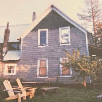 Sepia-toned archival photograph of the original Watson's lodge building with Adirondack chairs out front